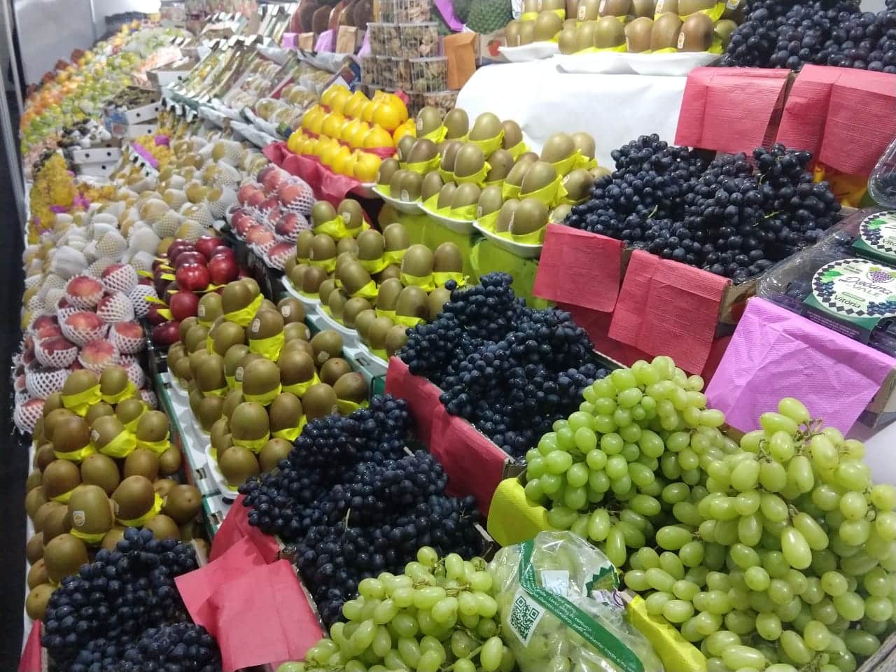 Foto mostra várias frutas expostas em caixas.