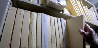 foto mostra uma estante com vários volumes