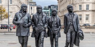 foto mostra as estátuas dos quatro integrantes da banda nas ruas de Liverpool